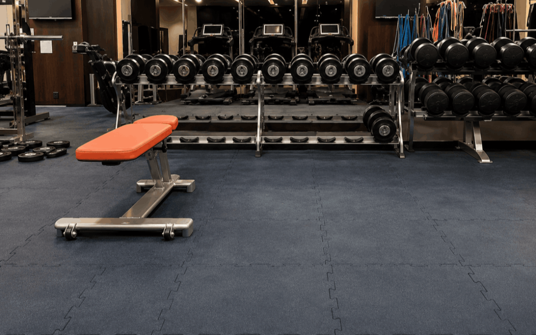 Floor suitable for fitness room with gym equipment and dark interlocking floor tiles