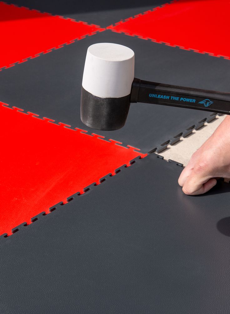 Installing interlocking garage floor tiles with a rubber mallet