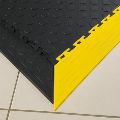 Yellow floor ramp edging fitted to interlocking PVC tiles
