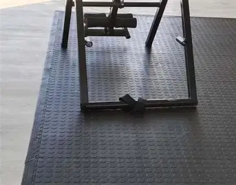 Rubber mats installed under gym equipment for floor protection