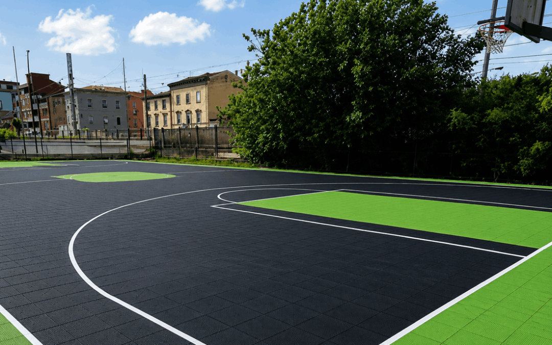 Modular sports tiles on a black and green outdoor basketball court