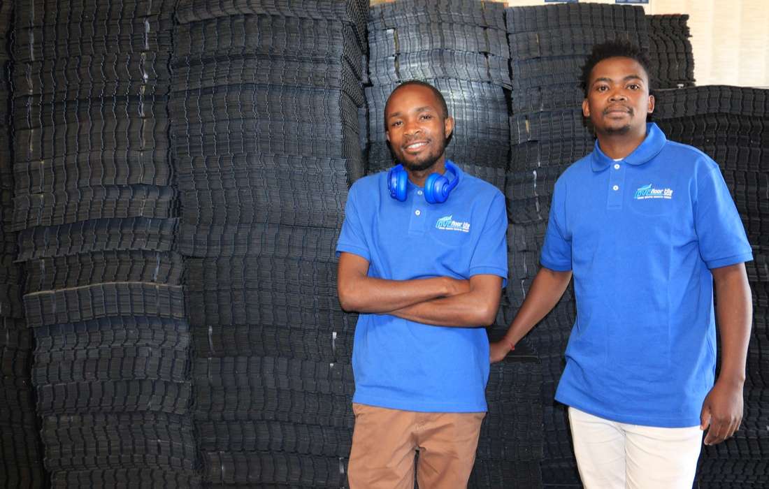 PVC Floor Tile team members standing with interlocking flooring stock
