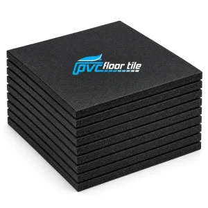 Stack of black heavy-duty rubber gym tiles with textured surface