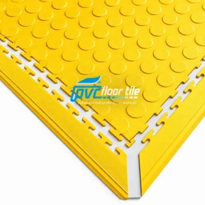 Yellow interlocking PVC floor tile with studded surface and corner edging detail